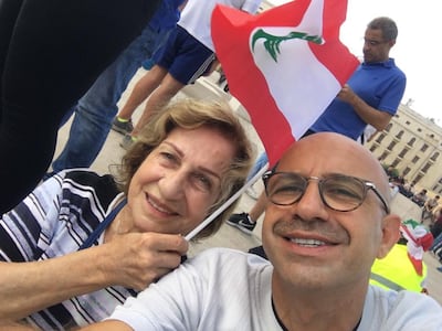 The author's grandmother and father, holding a Lebanese flag during protests.