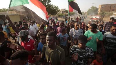 Sudanese protesters wave national flags during a rally. AFP