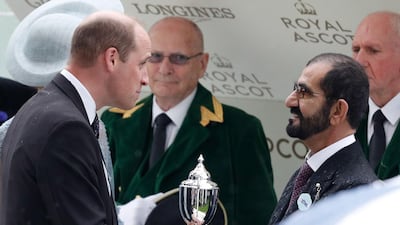Prince William, Duke of Cambridge, presents a trophy to Sheikh Mohammed bin Rashid, Prime Minister and Ruler of Dubai, after Blue Point won the King's Stand Stakes on Day 1 of Royal Ascot. AFP