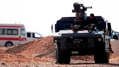 Members of the Egyptian security forces rest on an armoured vehicle parked on the road to Bahariya oasis in the Western Desert region where a police convoy was ambushed by militants on October 21, 2017. Mohamed El Shahed / AFP