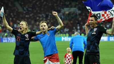 Croatia players Domagoj Vida, left, Ivan Rakitic, centre and Mario Mandzukic celebrate post-match against England in a scene where a number of the squad's families and children came on the pitch. EPA
