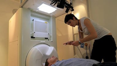 NYUAD PhD student, Esti Blanco-Elorrieta, places electromagnet sensors on a participant's forehead to monitor brain activity for her study at the neuroscience language lab. Courtesy Esti Blanco-Elorrieta