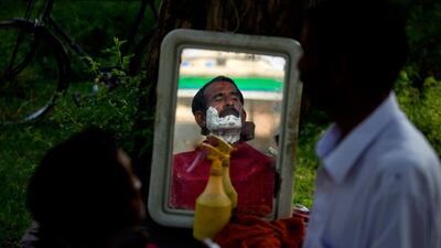 A Pakistani man waits for a barber on a roadside, in Islamabad, Pakistan. B.K. Bangash / AP Photo