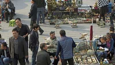 Uighur jade vendors wait for customers at an outdoor market where Chinese police have been checking their IDs daily since a vehicle attack in Beijing, Ng Han Guan / AP