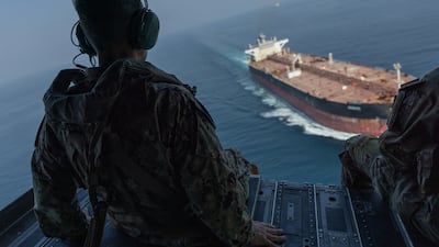 US Navy Adm Brad Cooper commander of US Central Command, observes a commercial vessel transiting the Strait of Hormuz from a helicopter at the weekend. Photo: US Central Command