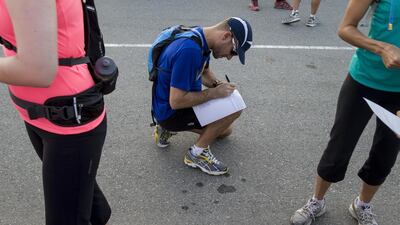 A runner completes a waiver form before the start of the 12.5km trail run. A group of like-minded individuals met up for The North Face Trail Running Event, which aims to establish trail running as a sport in the UAE. Antonie Robertson/The National