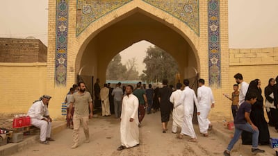 Iraqi Muslims visit a cemetery during a dust storm on the first day of Eid Al Fitr at the cemetery of Hassan Al Basri in the Zubayr District of Iraq's southern Basra governorate. AFP