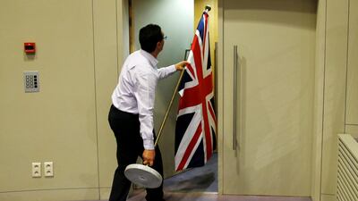 An official carries a Union Jack flag ahead of a news conference by Britain's Brexit secretary David Davis. The UK has outlined proposals for new border policies. Francois Lenoir / Reuters