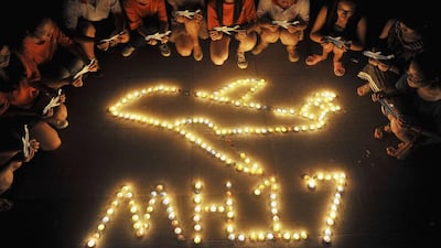 College students gather around candles forming the shape of an airplane, during a candlelight vigil for victims of the downed Malaysia Airlines Flight MH17, at a university in Yangzhou, Jiangsu province on Saturday. Ukraine accused Russia and pro-Moscow rebels on Saturday of destroying evidence of "international crimes" as guerrillas and foreign observers faced off over access to the wreckage of the downed Malaysian airliner. REUTERS/Stringer