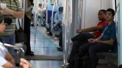 A contented passenger on the Dubai Metro listens to his own tunes.
