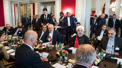 Swiss Federal President Alain Berset, Iranian President Hassan Rohaniand and their delegation members sit at a table at the beginning of the delegation meeting. Peter Klaunzer/ EPA