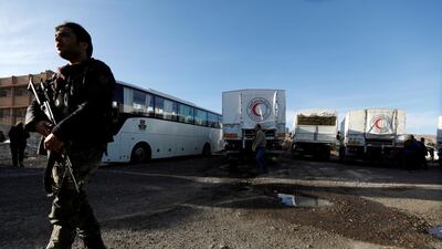 A Syrian soldier secures aid convoy after its return from eastern Ghouta in Damascus, Syria