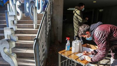 A resident fills a form prior to undergoing the Covid-19 test at the school sports hall. AFP