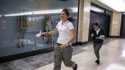 Leen Seifo, 15, runs out of the store after buying her ticket to see the One Direction, trailed by her friend Farah Abed, 15. Silvia Razgova / The National