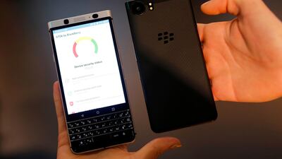 Hosts hold Blackberry KEYone mobilephones at the Mobile World Congress (MWC), the world's biggest mobile fair in Barcelona. AFP / Pau Barrena