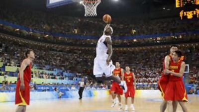 Yao Ming of China (second right) can only cower as Lebron James of America powers past him for a slam dunk during their Group B men's basketball game Dwayne Wade scored 19 points as the USA won the match, played in front of a capacity 18,000 crowd, 101-70.