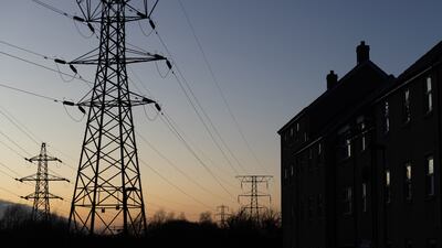 Electricity transmission pylons next to a block of flats in St Neots, England. Bloomberg