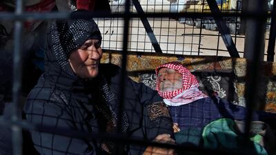 Sumaya Ramadan, left, sits next to her paralysed 92-year-old uncle Abdul-Moati Abu-Zeid, right, who laid on a mattress not moving or speaking, in a pickup truck getting ready to cross into Syria from the eastern Lebanese border town of Arsal, Lebanon, on June 28, 2018. Bilal Hussein / AP Photo