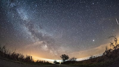 The milky way and traces of meteors illuminate the sky over Burg on the Baltic Sea island of Fehmarn, northern Germany. Daniel Reinhardt / dpa via AP.