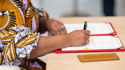 A dignitary accompanying the Democratic of Congo delegation signs the agreement at Al Shati Palace
