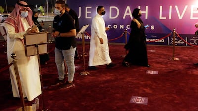 Concert-goers show their coronavirus vaccine certificates as they enter the arena.