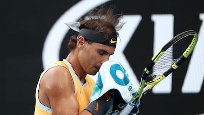 Rafael Nadal wipes his face with a towel during the match. Reuters