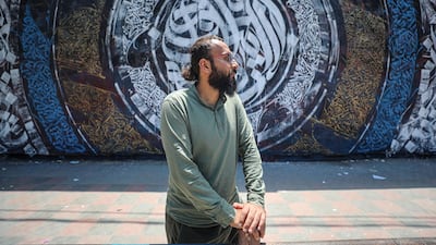 Bilal Khaled in front of an example of his graffiti on a wall at Alazhar University in Gaza City. All photos: Nagham Mohanna for The National