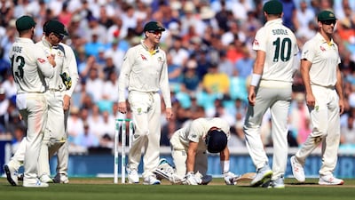 Joe Denly down on his knees after being struck by a painful blow at The Oval. PA