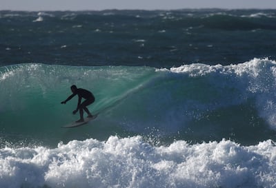 A surfer rides a wave in Cornwall, south-west England. Reuters