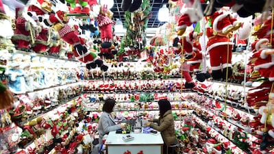 Women sit in a store selling Christmas products at the Yiwu Wholesale Market in Yiwu, Zhejiang province, China. Reuters