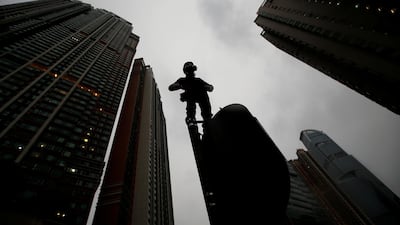 A demonstrator stands on a traffic light during a protest in Hong Kong, China. Reuters