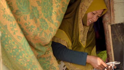 A Cambodian-Muslim woman checks her smartphone at her home on the Mekong river in Phnom Penh.Tang Chhin Sothy / AFP Photo