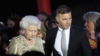 Queen Elizabeth and musician Gary Barlow on stage during the diamond jubilee concert at Buckingham Palace. Getty