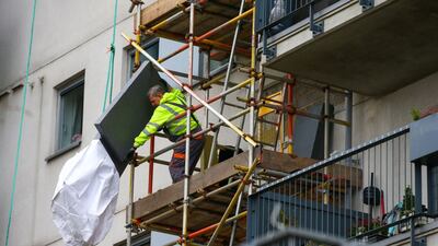 A construction worker inspects cladding at residential apartments in London. Hollie Adams / Bloomberg