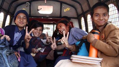 Children wave victory signs as they leave the school. Nadeem Khawer / EPA