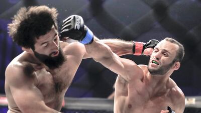 Jarrah Al Selawi, right, lands a punch on Abdoul Abdouraguimov during their weltweweight title bout at Brave CF 27 at Mubadala Arena. Victor Besa / The National
