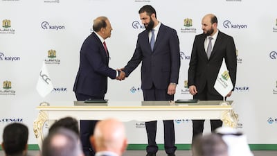 Syria's President Ahmad Al Shara, centre, shakes hands with Orhan Cemal Kalyoncu, chairman of Kalyon Holding, as Syrian Minister of Energy Mohammad Al Bashir watches, after the signing of the agreement in Damascus. AP