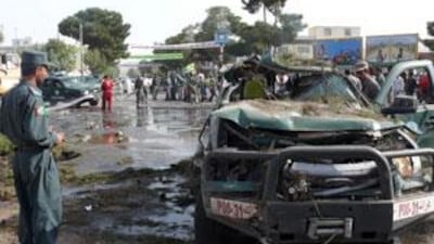 Afghan policemen stand guard at the site of a bomb blast in Herat on August 3, 2009.