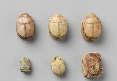 Six scarab seals were found inside one of the light-blue vessels in the tomb. Photo: Egyptian Ministry of Tourism and Antiquities