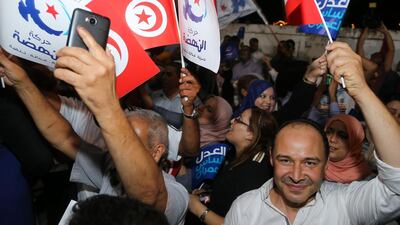 Suppoters of the Tunisian Islamist-inspired Ennahdha party celebrate in reaction to the first exit polls in front of the party's office in the capital Tunis. AFP