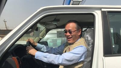 Ambassador Fumio Iwai rides in a pickup truck during a handover ceremony of vehicles provided by Japan to the Iraqi police on March 21, 2018. AFP