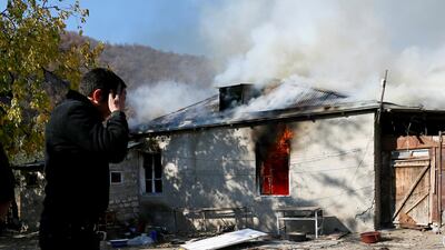 A man reacts as he stands near a house set on fire by departing Ethnic Armenians, in an area which is soon to be turned over to Azerbaijan, in the village of Cherektar. Reuters