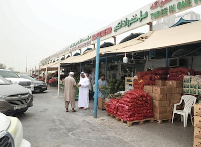 Customers shop at the Mina Zayed fruit and vegetable market. Victor Besa / The National