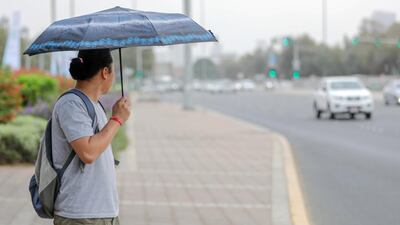 A commuter waits for the bus to arrive. Victor Besa / The National