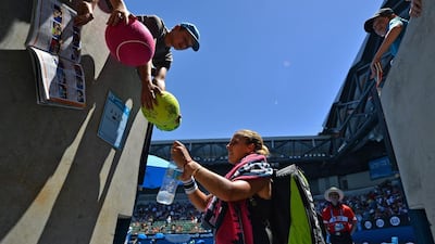 Dominika Cibulkova of Slovakia signs autographs following her victory over Francesca Schiavone of Italy. Saeed Khan / AFP