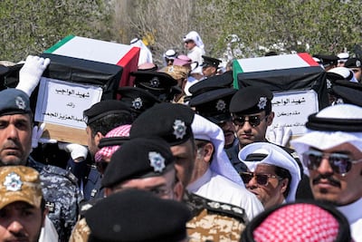 Kuwaiti policemen carry the caskets of two border guards killed while on duty. AFP