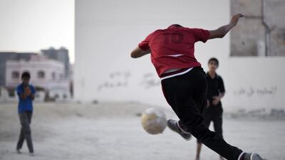 Bahraini boys play football in the village of Barbar, west of the capital Manama. Mohammed Al-Shaikh / AFP