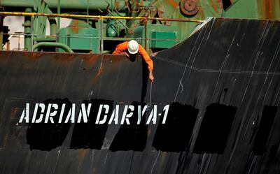A crew member takes pictures with a mobile of the new name, the Adrian Darya 1, painted over the space that used to carry the name Grace 1. Reuters
