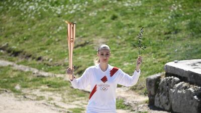 Torchbearer Greece's Anna Korakaki, Rio 2016 gold medallist in the 25m pistol shooting, holds the Olympic flame and an olive branch during the flame lighting ceremony. AFP