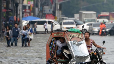 A commuter holds on to his shoes in tricycle. AFP